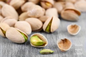 Pistachio nuts on wooden background